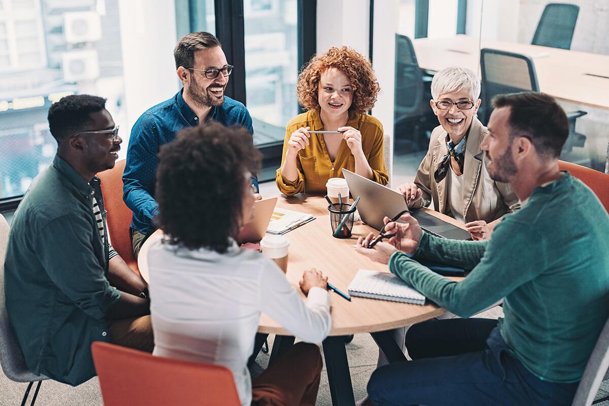 mixed group of business people siting around a table discussion