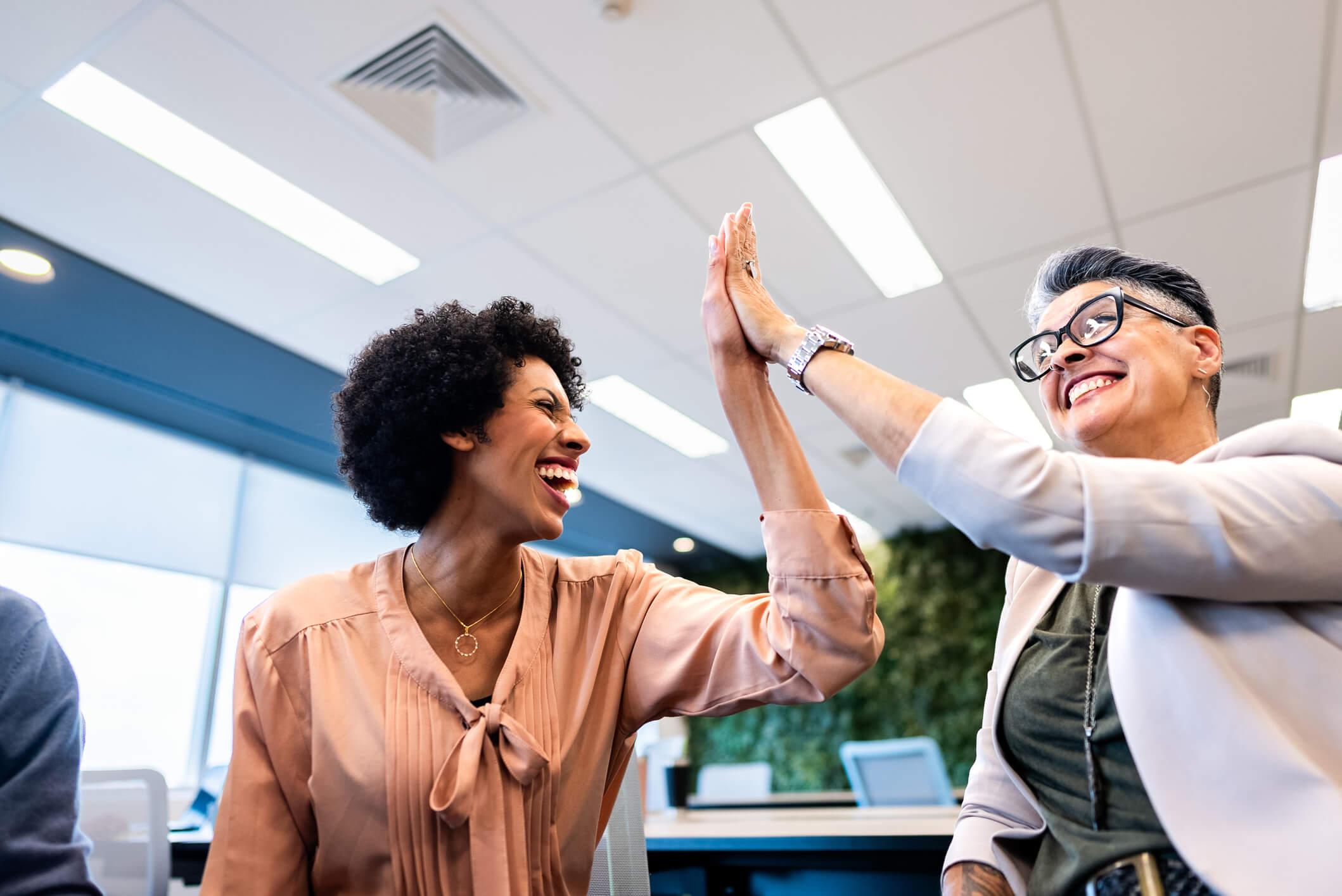 coworkers doing high five on the office