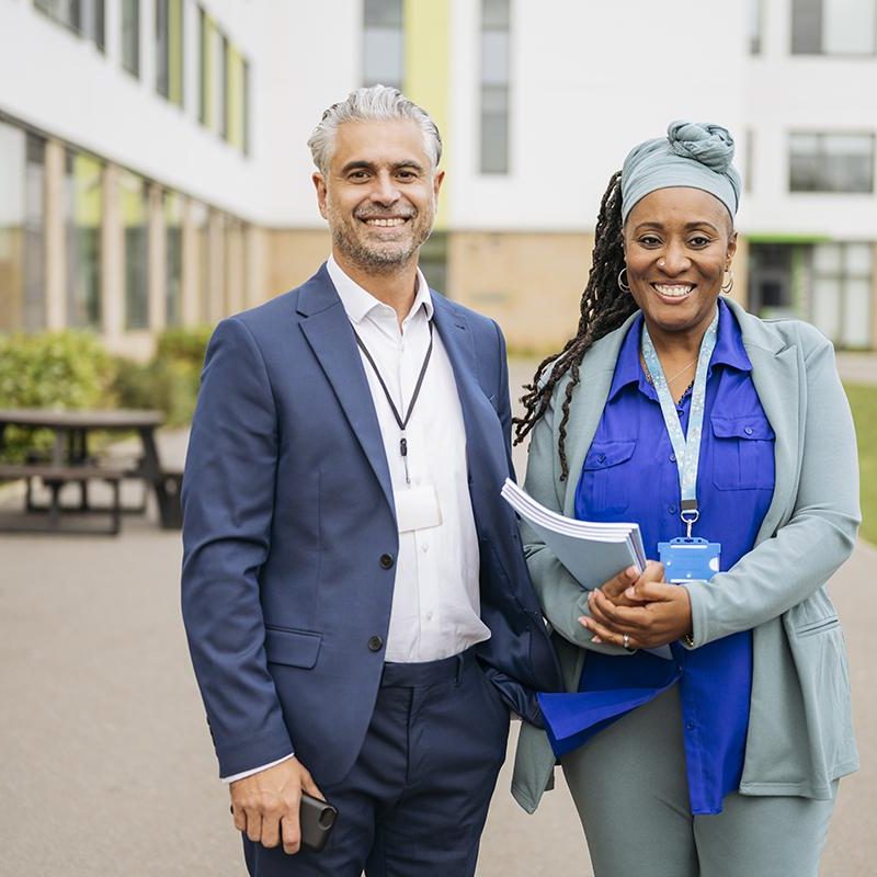 Portrait of cheerful teachers on secondary school campus