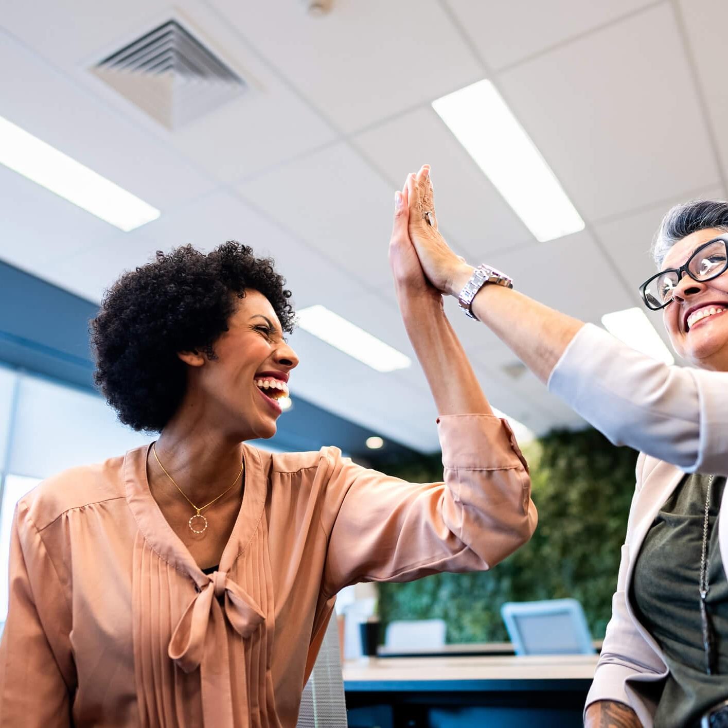 coworkers doing high five on the office